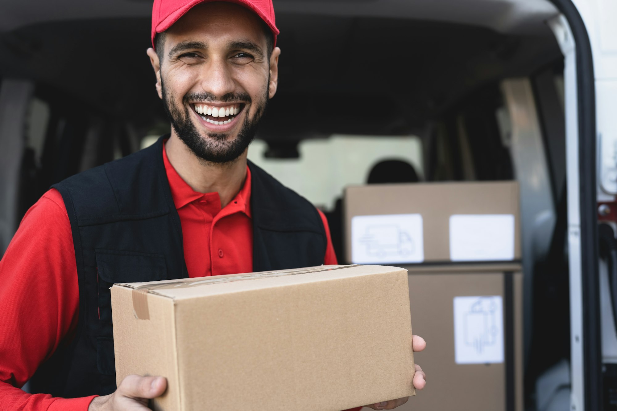 Young delivery man carrying cardboard box - People working with fast deliver transportation