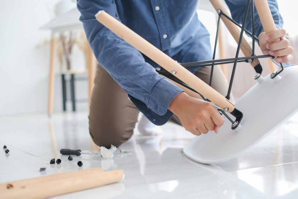 Young man doing DIY work, assembling furniture at home.